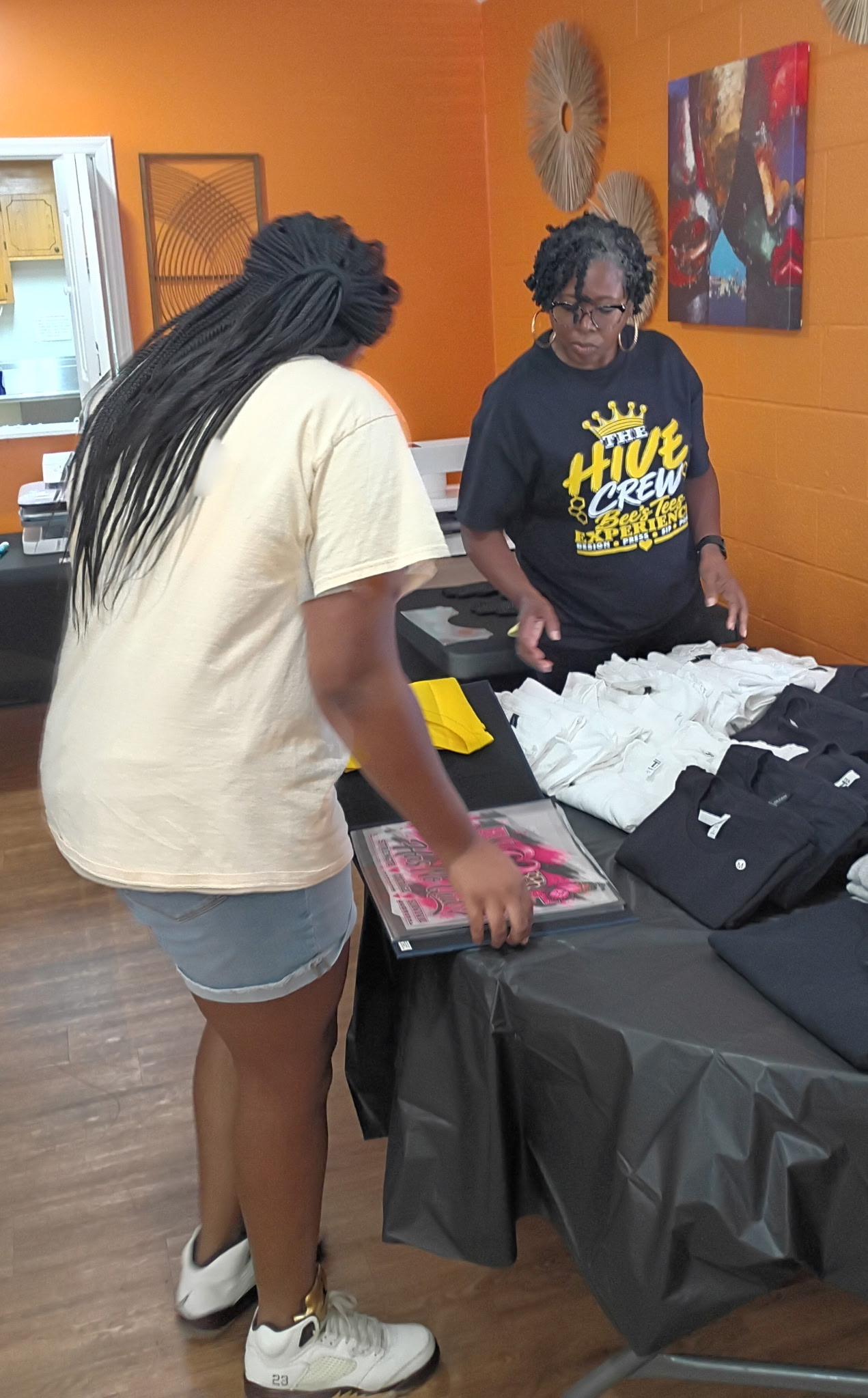 Bee's Tees Hive Crew preparing shirts and design choices for guests